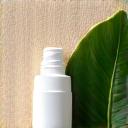 Sunscreen bottle next to a leaf